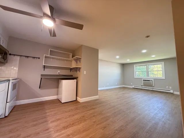 an empty room with wooden floor and window
