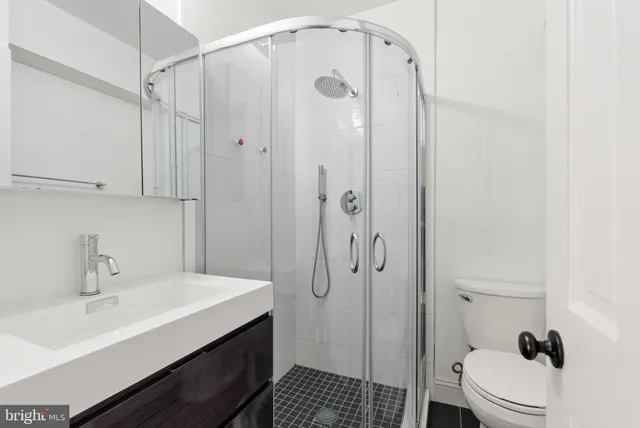 a bathroom with a sink a toilet and shower