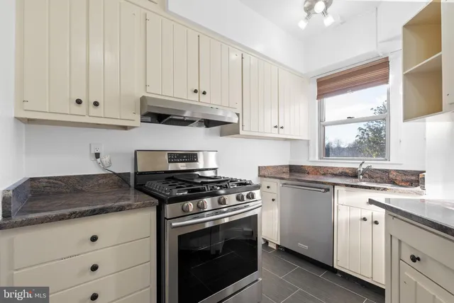 a kitchen with granite countertop white cabinets and white appliances