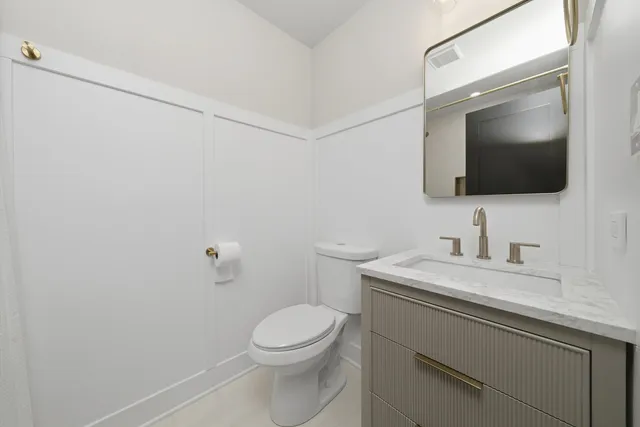 a bathroom with a toilet sink and mirror