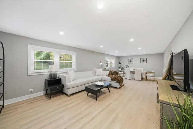 a living room with furniture a flat screen tv and a window