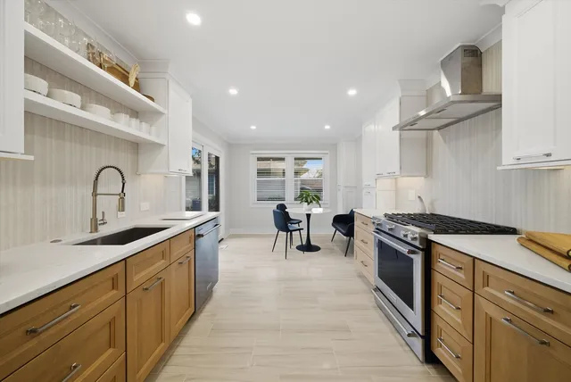 a kitchen with stainless steel appliances granite countertop a sink stove and refrigerator