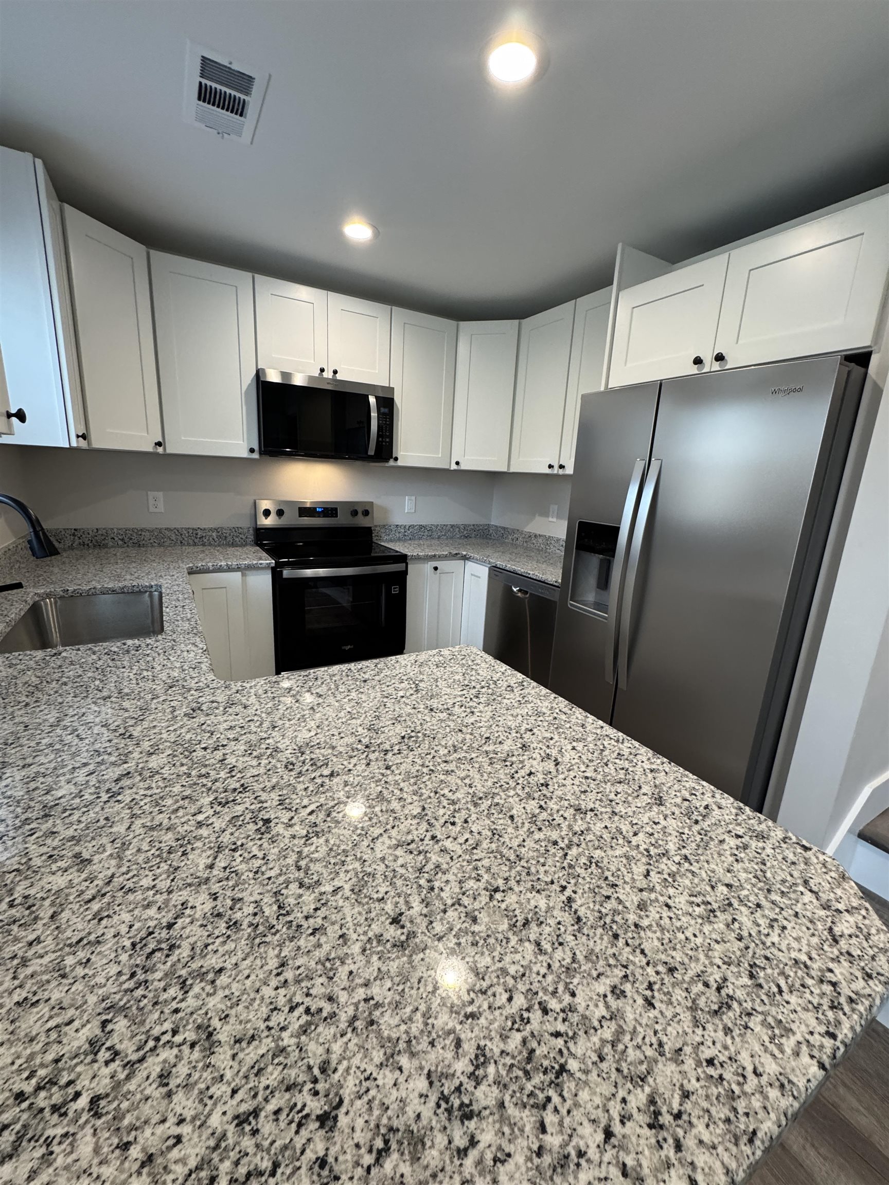 311 East Ripley Avenue Covington, TN 38019 - Photo 15 of 37 Kitchen with stainless steel appliances, white cabinets, light granite countertops, a peninsula, and recessed lighting