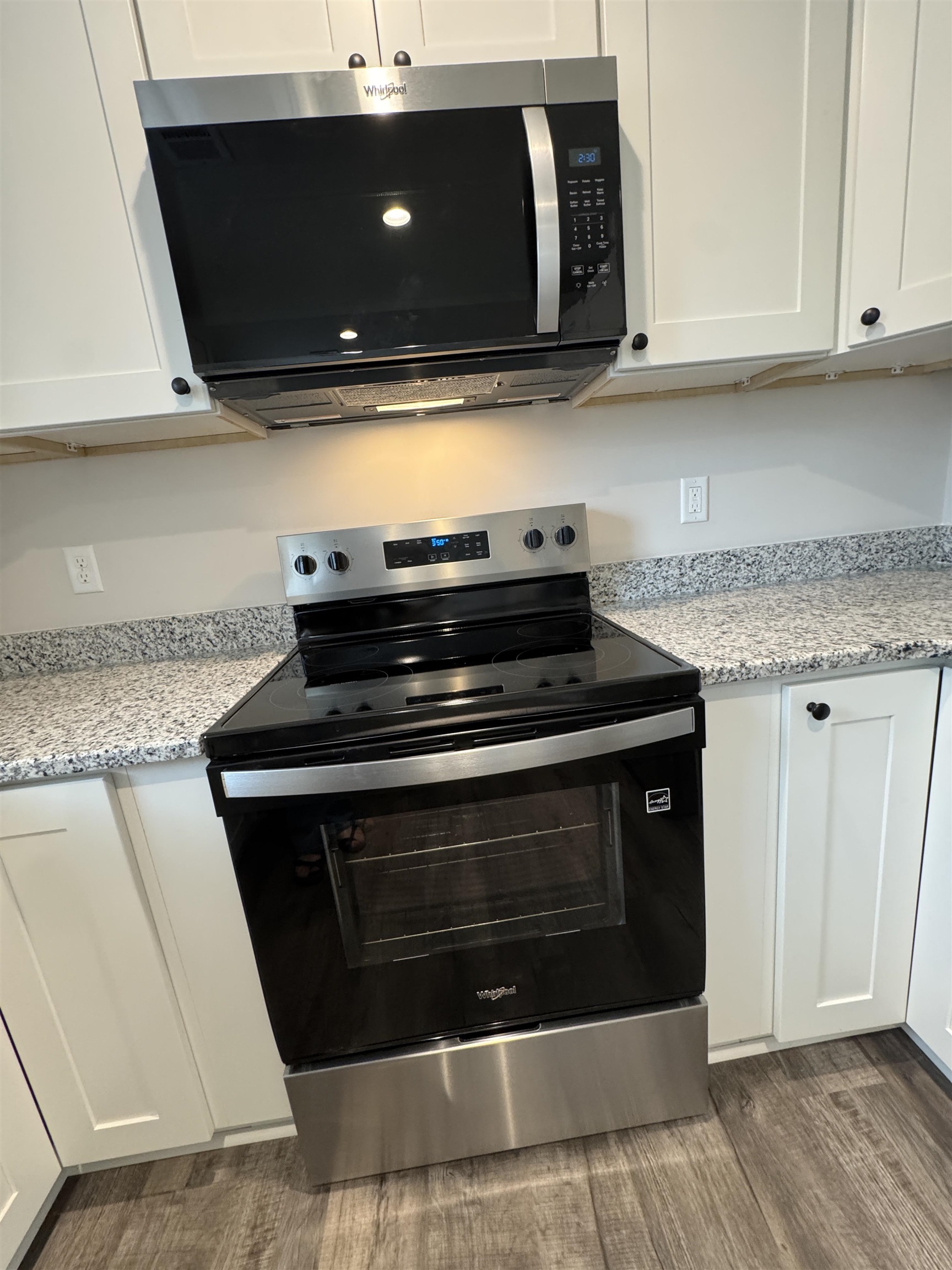 311 East Ripley Avenue Covington, TN 38019 - Photo 19 of 37 Kitchen with stainless steel appliances, white cabinetry, light granite counters, and dark wood-type flooring