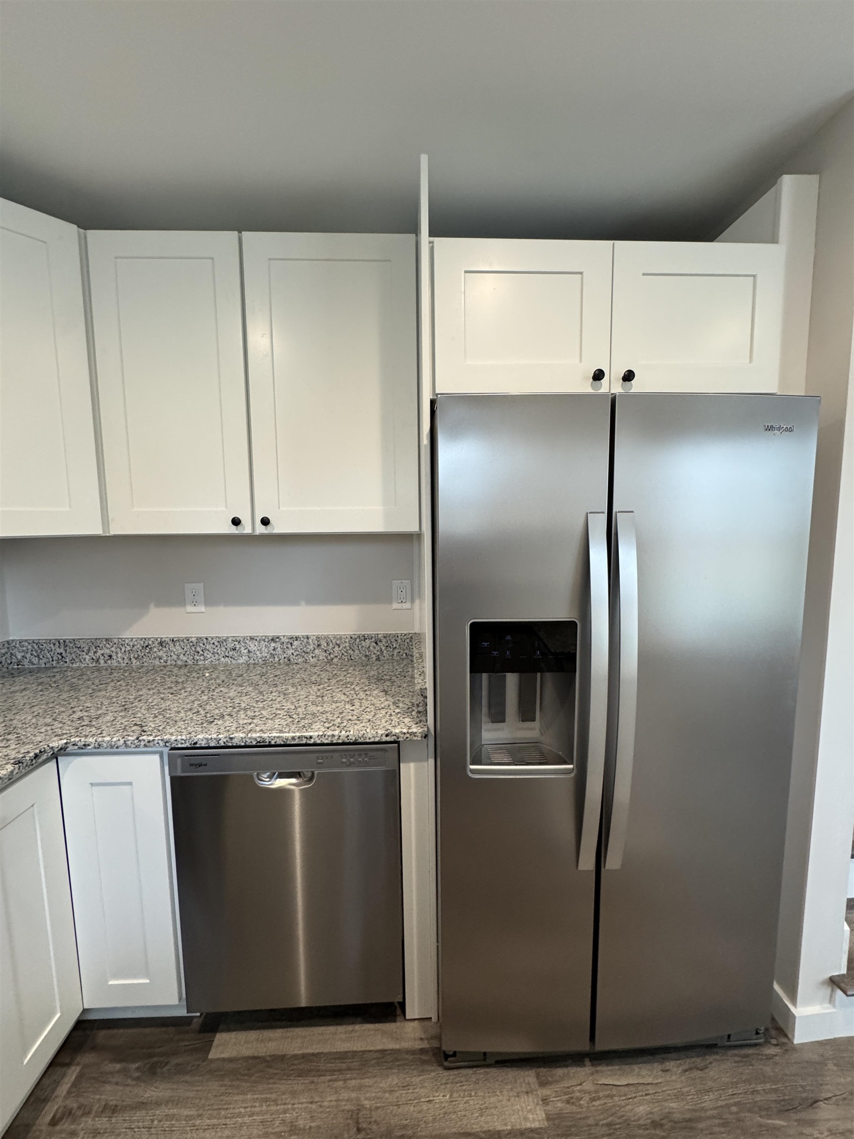 311 East Ripley Avenue Covington, TN 38019 - Photo 20 of 37 Kitchen with stainless steel appliances, white cabinets, lazy susan #3, light granite countertops, and dark wood-style flooring