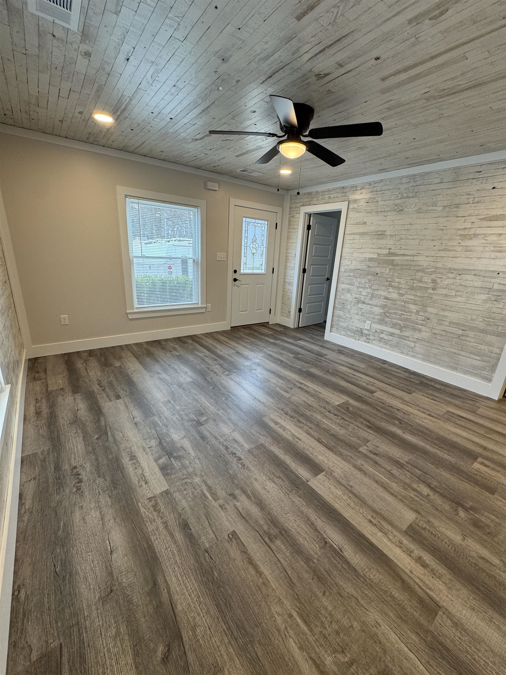 311 East Ripley Avenue Covington, TN 38019 - Photo 24 of 37 an empty room with wooden floor ceiling fan and windows