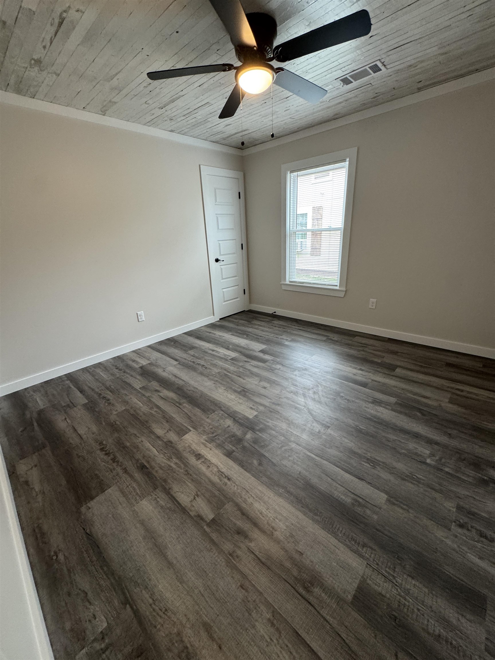 311 East Ripley Avenue Covington, TN 38019 - Photo 25 of 37 an empty room with wooden floor ceiling fan and windows