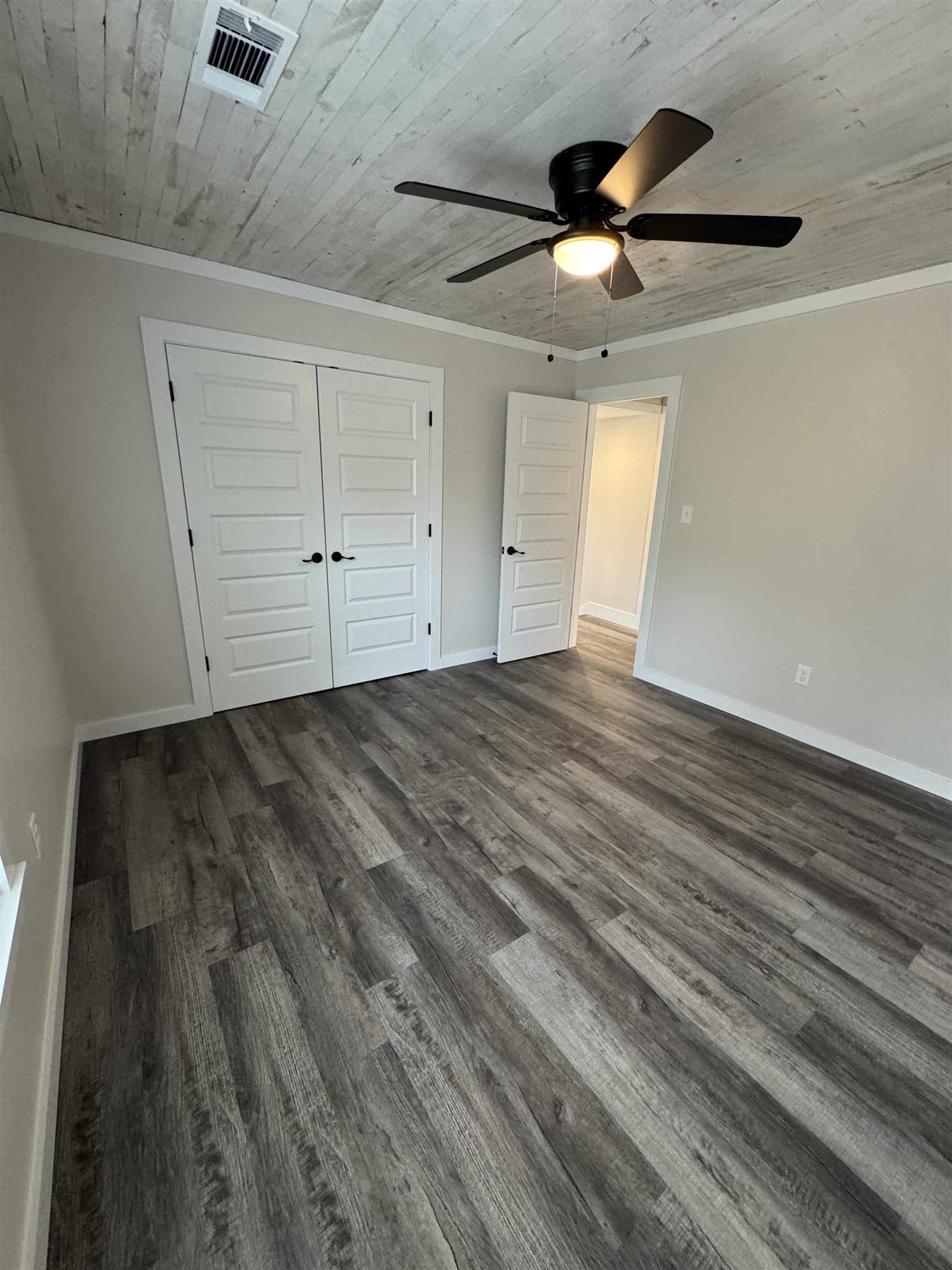 311 East Ripley Avenue Covington, TN 38019 - Photo 27 of 37 an empty room with wooden floor ceiling fan and windows