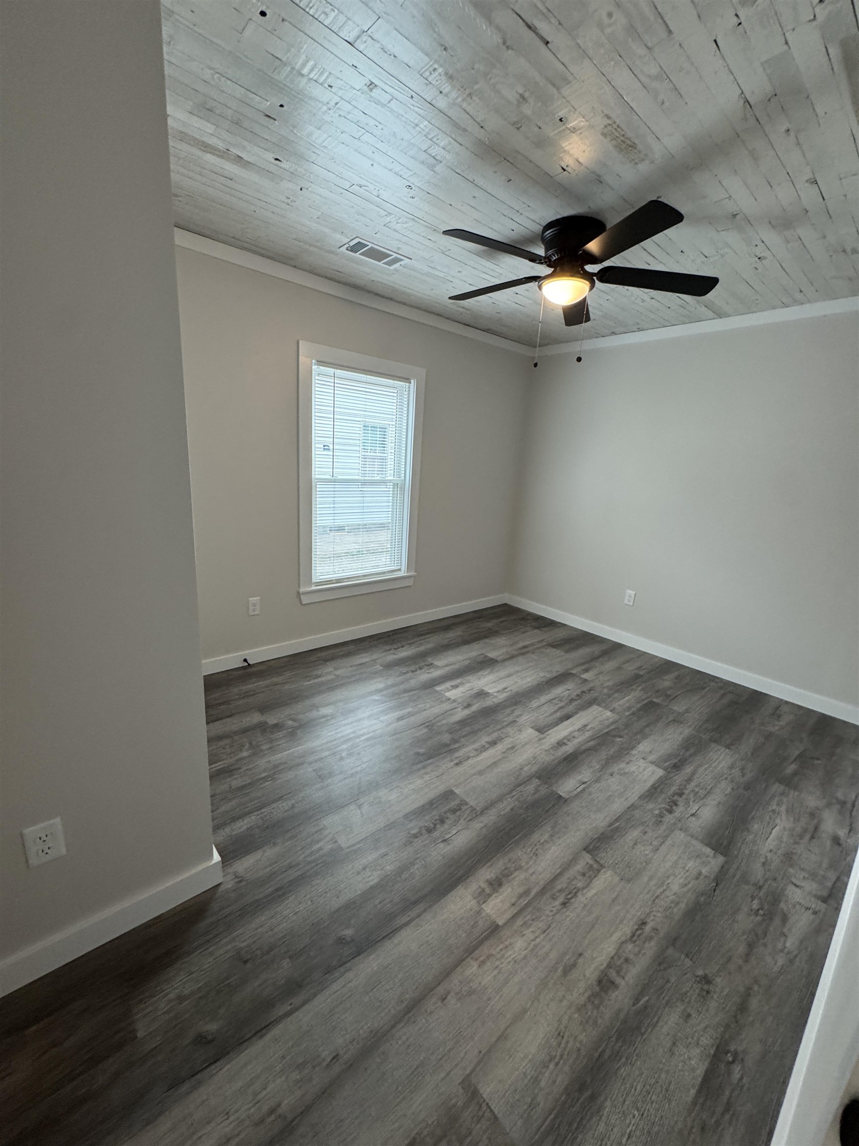 311 East Ripley Avenue Covington, TN 38019 - Photo 8 of 37 an empty room with wooden floor ceiling fan and windows