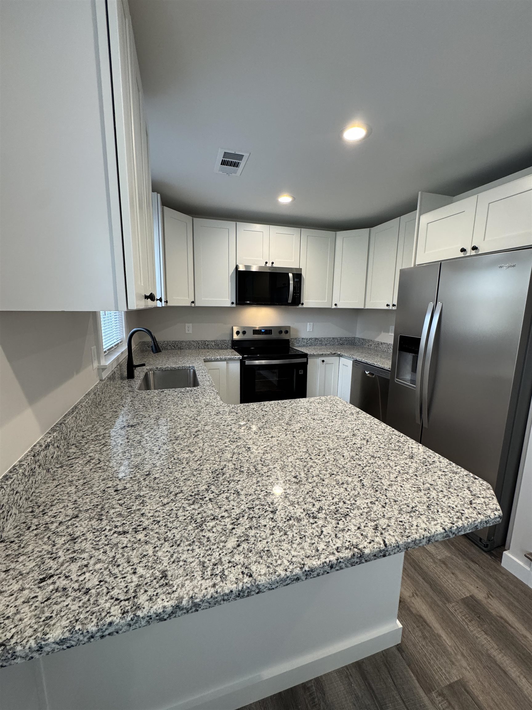 311 East Ripley Avenue Covington, TN 38019 - Photo 10 of 37 a kitchen with stainless steel appliances kitchen island granite countertop a sink refrigerator and microwave