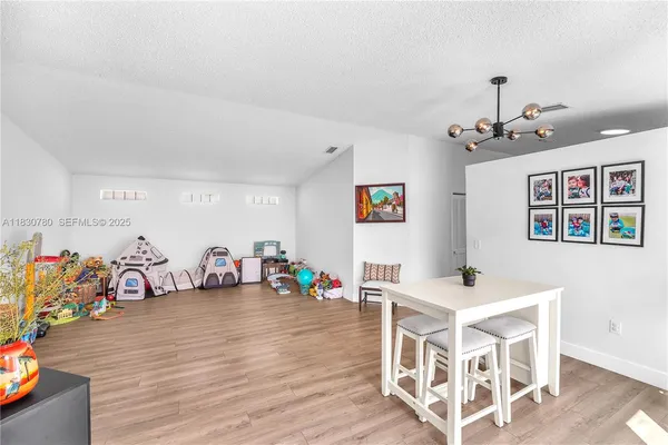 a view of a room with furniture and wooden floor