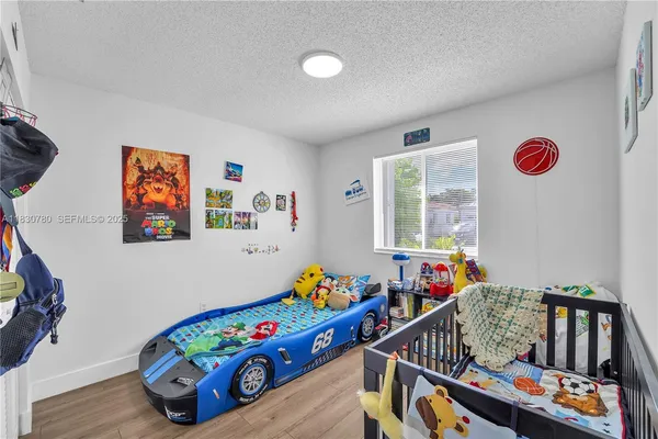 a bedroom with furniture a baby crib and a window