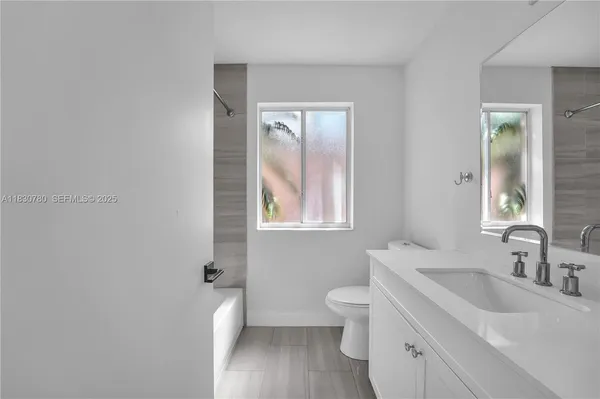 a bathroom with a toilet sink and mirror