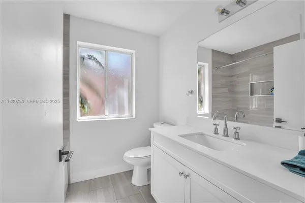 a bathroom with a toilet a sink and mirror
