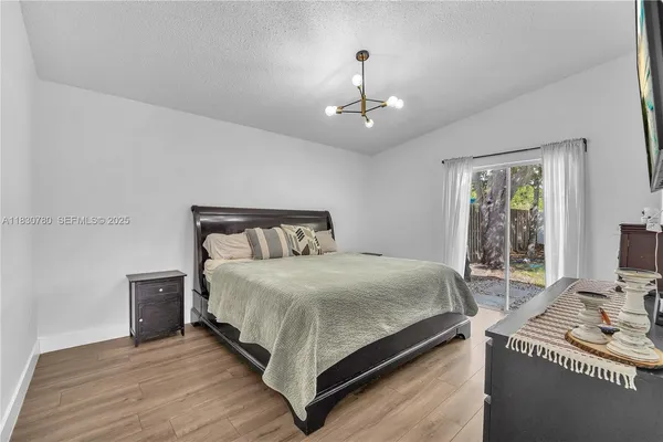 a bedroom with a bed wooden floor and window