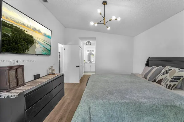 a spacious bedroom with a bed and a flat screen tv