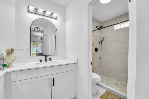 a bathroom with a sink a toilet and shower