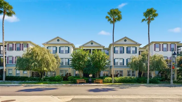a front view of a house with a yard and palm trees