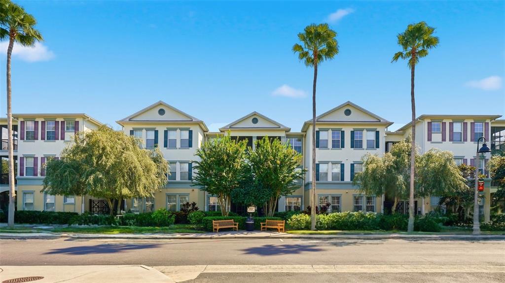 a front view of a house with a yard and palm trees