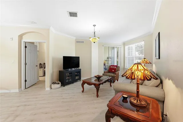 a living room with furniture a chandelier and a flat screen tv