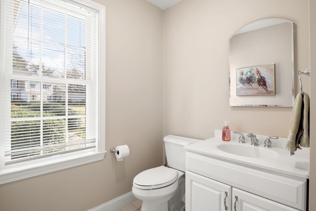 101 Tussock Brook Road, Unit 101 Duxbury, MA 02332 - Photo 15 of 38 a bathroom with a toilet sink vanity and mirror