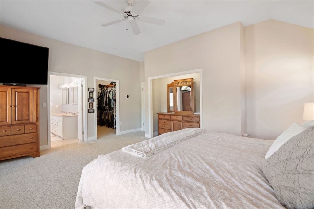 101 Tussock Brook Road, Unit 101 Duxbury, MA 02332 - Photo 17 of 38 a bedroom with a bed and a flat tv screen on wall