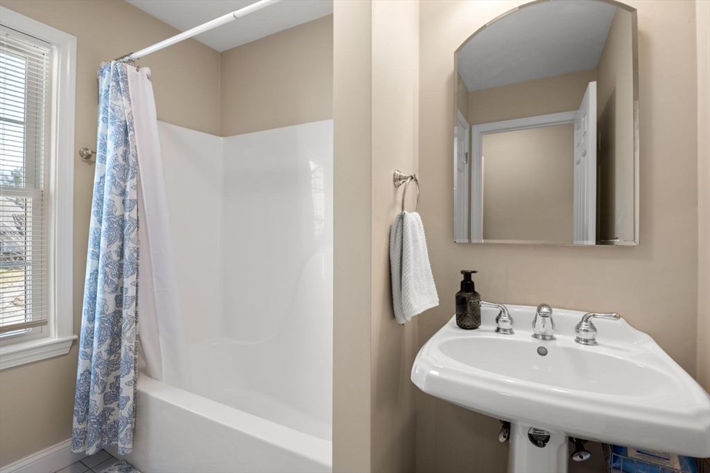 101 Tussock Brook Road, Unit 101 Duxbury, MA 02332 - Photo 24 of 38 a bathroom with a sink a mirror and a bathtub