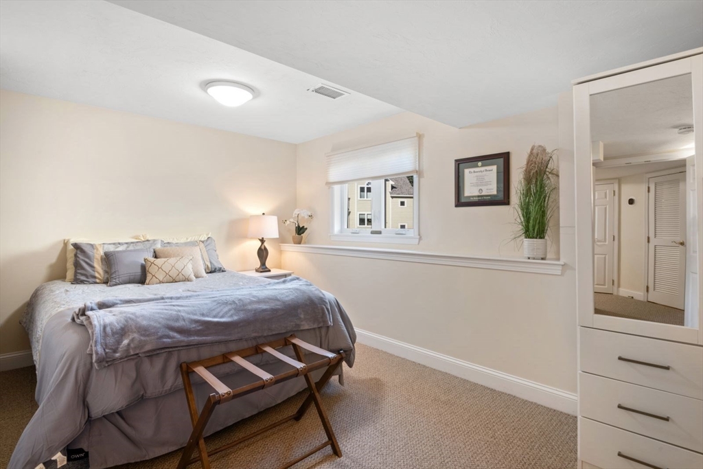 101 Tussock Brook Road, Unit 101 Duxbury, MA 02332 - Photo 32 of 38 a bedroom with a bed and a table