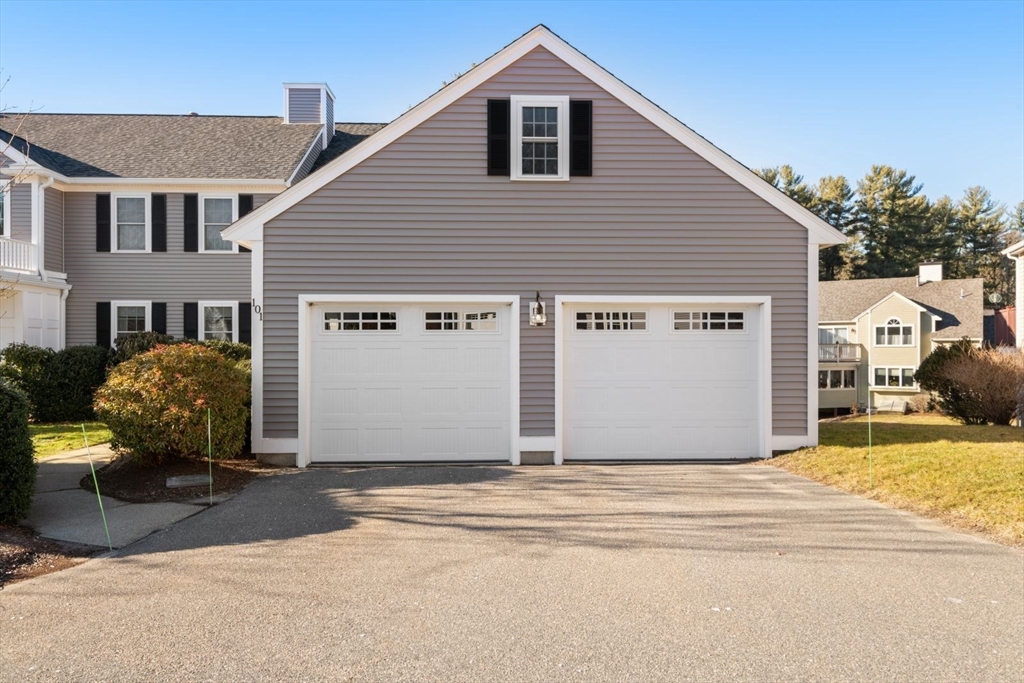 101 Tussock Brook Road, Unit 101 Duxbury, MA 02332 - Photo 35 of 38 a front view of a house with a yard and garage