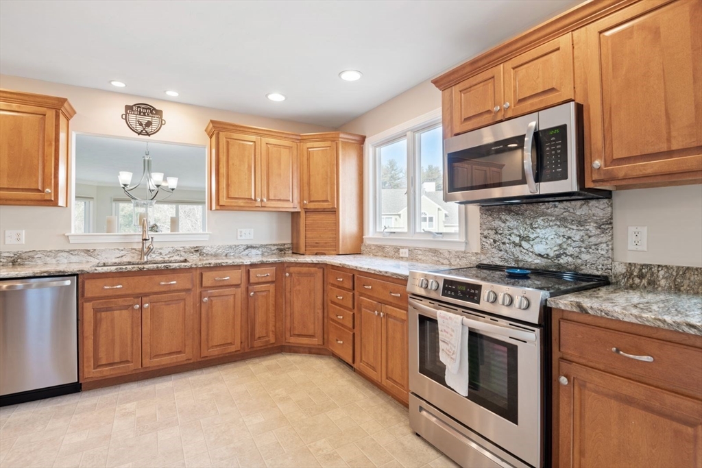101 Tussock Brook Road, Unit 101 Duxbury, MA 02332 - Photo 4 of 38 a kitchen with stainless steel appliances granite countertop a stove top oven a sink dishwasher and microwave oven