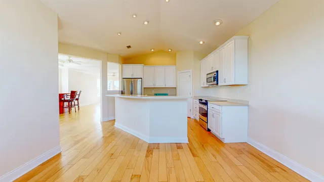 a kitchen with granite countertop a sink cabinets and wooden floor