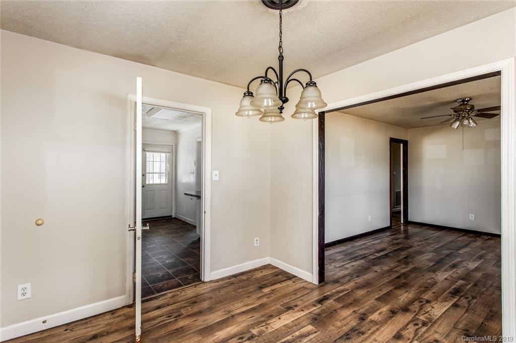 1314 Love Road Monroe, NC 28110 - Photo 21 of 36 a view of a hallway with a chandelier and wooden floor