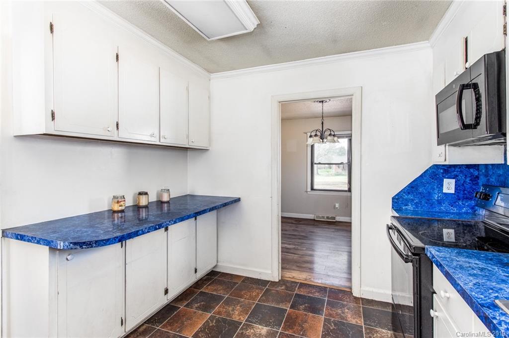 1314 Love Road Monroe, NC 28110 - Photo 26 of 36 a kitchen with granite countertop a sink a stove and cabinets