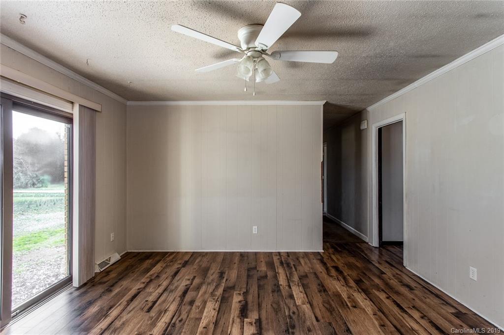 1314 Love Road Monroe, NC 28110 - Photo 7 of 36 an empty room with wooden floor fan and windows