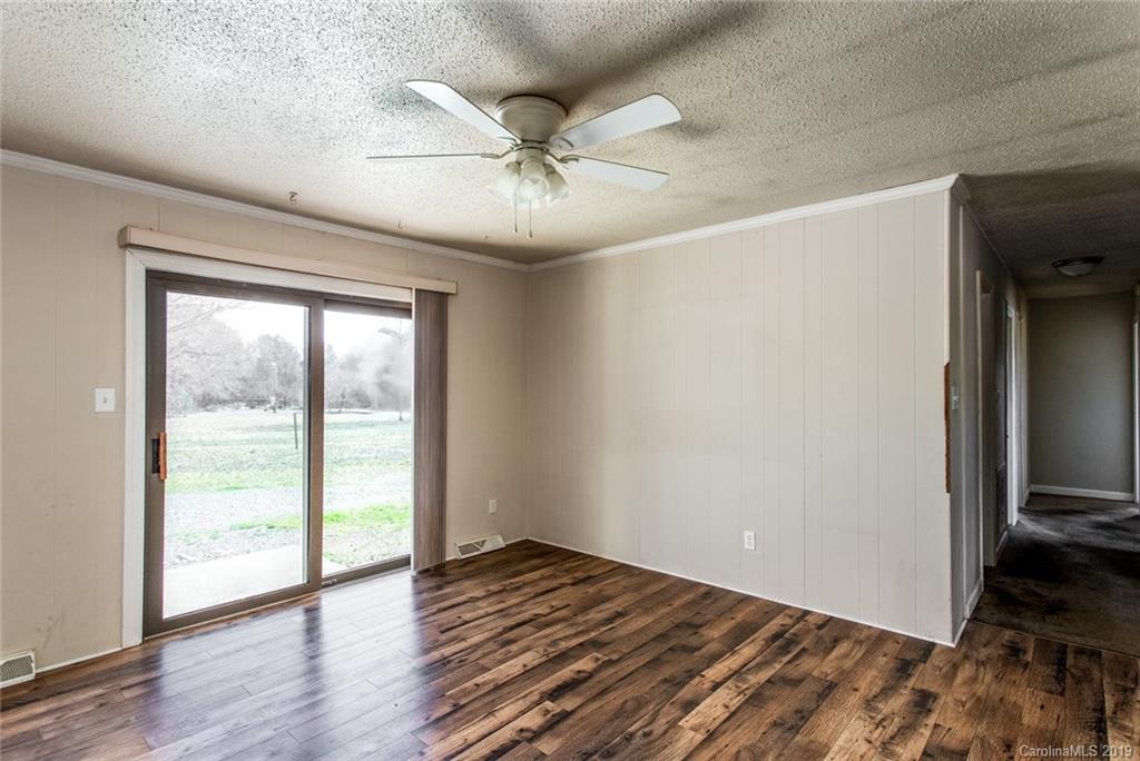 1314 Love Road Monroe, NC 28110 - Photo 9 of 36 an empty room with wooden floor fan and windows