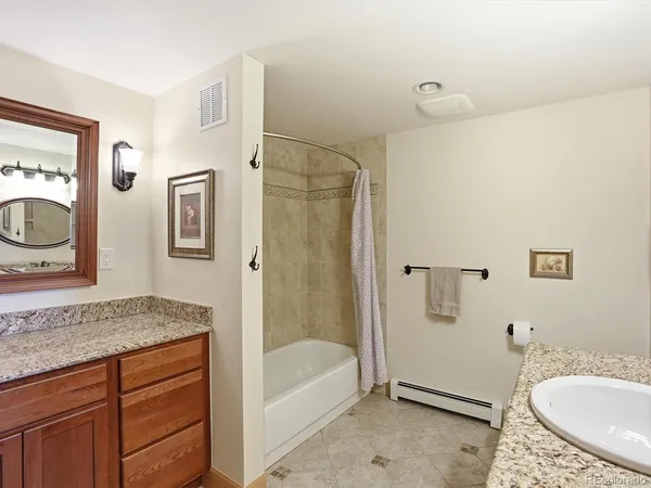 a bathroom with a granite countertop toilet a sink and a mirror