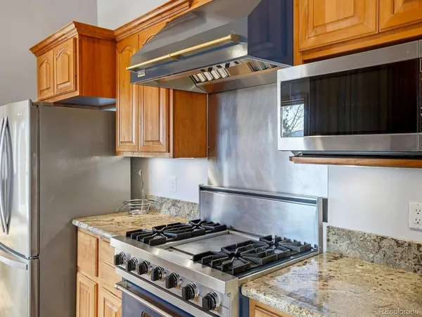 a kitchen with stainless steel appliances granite countertop a stove and a microwave