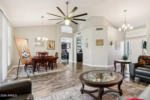 a dining room with wooden floor a chandelier a wooden table and chairs