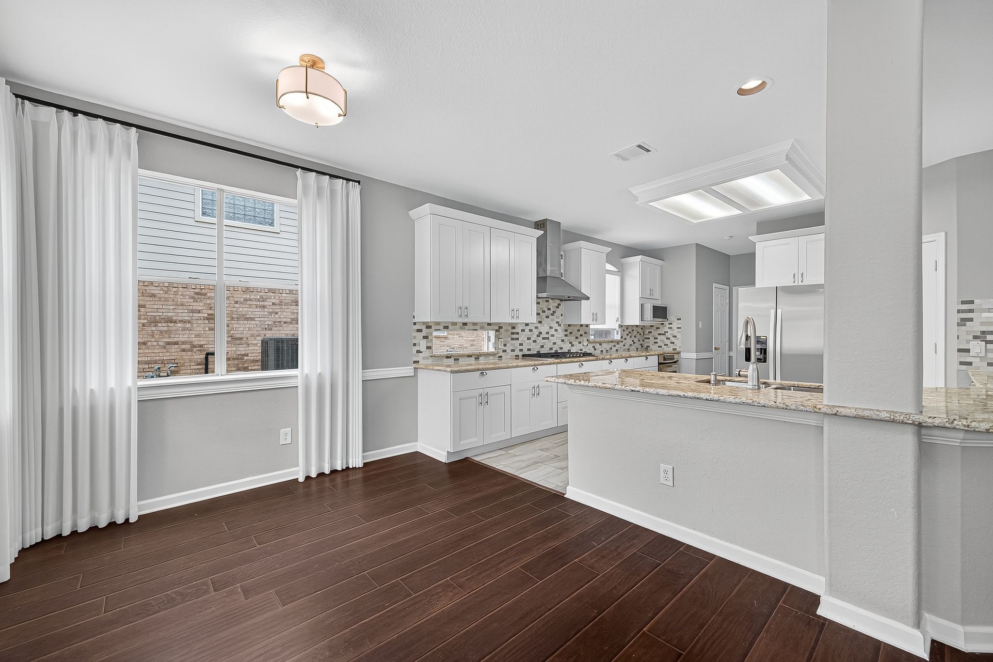 22406 Piper Terrace Lane Katy, TX 77450 - Photo 16 of 44 a kitchen with wooden floors and white cabinets