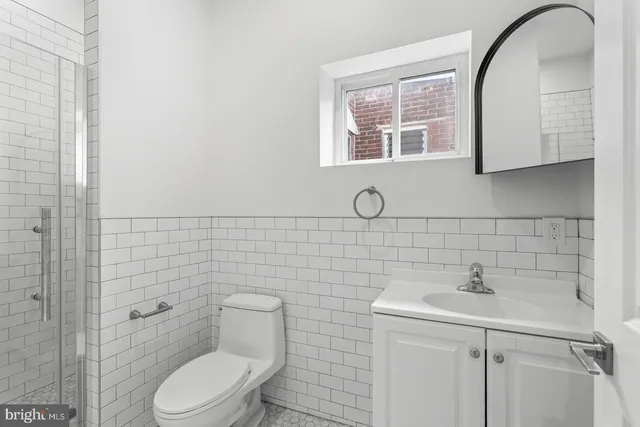 a bathroom with a toilet sink and mirror