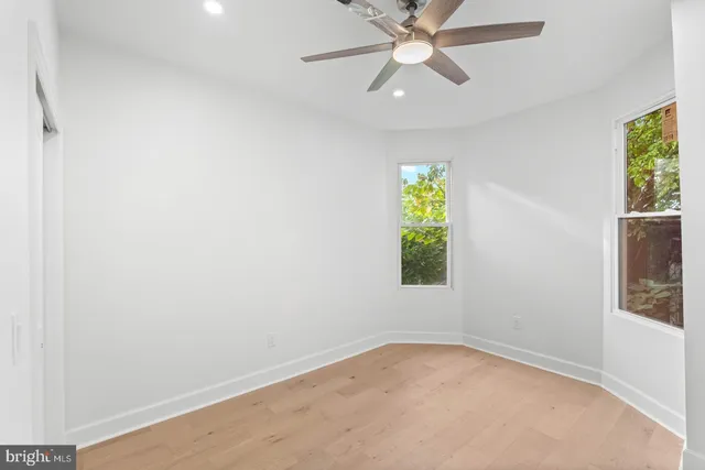 an empty room with window and fan
