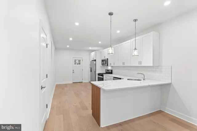 a view of a kitchen with a sink and chandelier