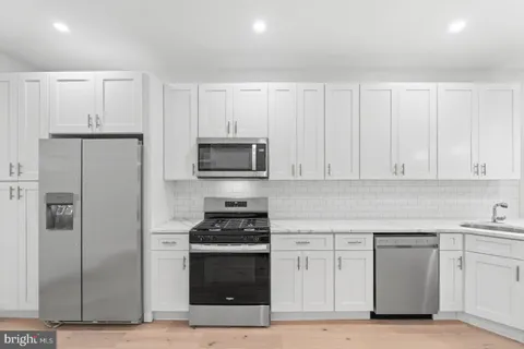 a kitchen with white cabinets and stainless steel appliances