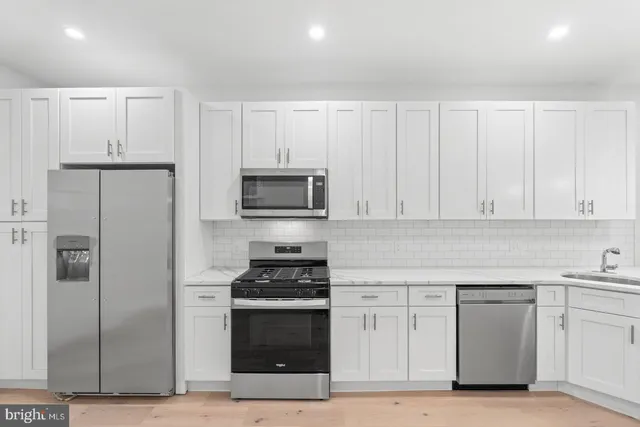 a kitchen with white cabinets and stainless steel appliances