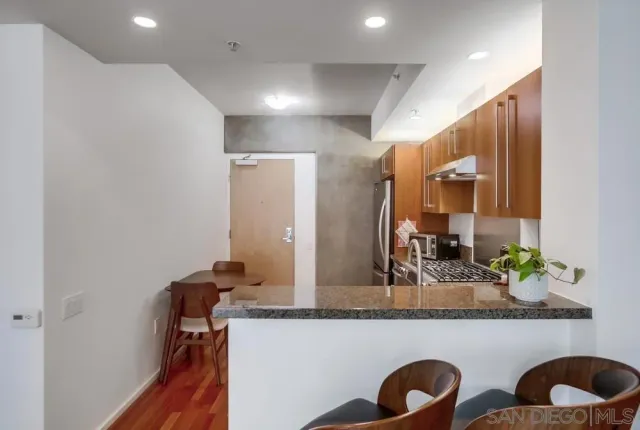 a bathroom with a granite countertop sink a mirror and shower