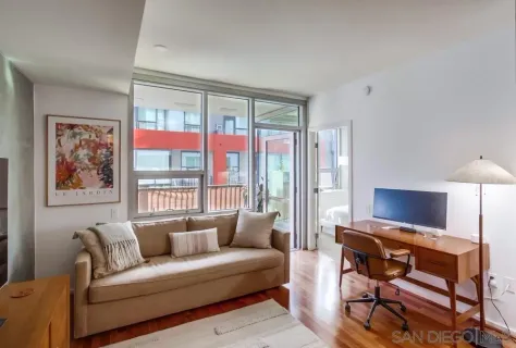 a living room with furniture a flat screen tv and a window