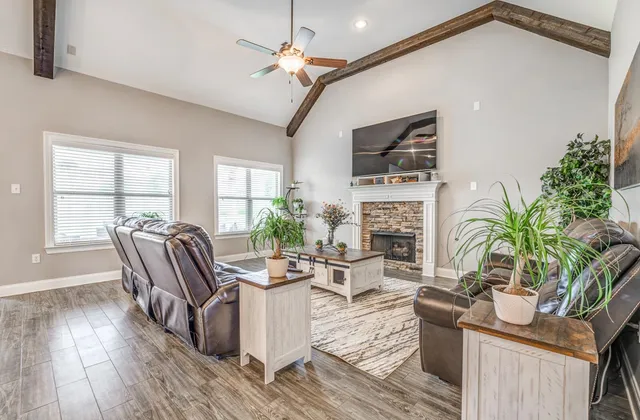 a living room with furniture a flat screen tv and a fireplace