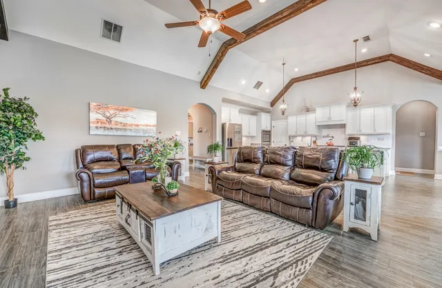 a living room with furniture kitchen view and a potted plant