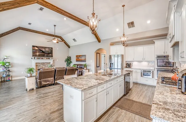 a kitchen with stainless steel appliances granite countertop a lot of counter space and wooden floors