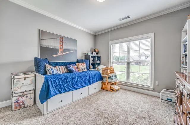 a bedroom with furniture and a large window